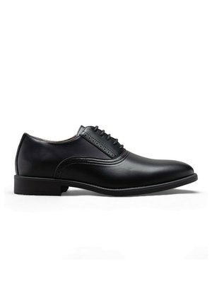 Chaussure oxford formelle noire en cuir avec laçage fermé, petit talon, et finition lisse et polie, présentée de profil sur fond blanc.
