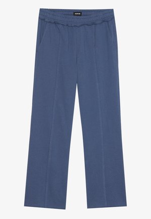 Lichtblauwe, wijde broek van zacht materiaal, met een elastische tailleband en twee zijzakken. Verticale naden lopen langs de voorkant.