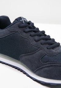 Marina sneakers med en kombination av mesh och mocka-material, rundad form och texturerade detaljer på ovandelen. Gummisulor med bra grepp.