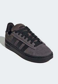 Szare zamszowe sneakersy z czarnymi akcentami, z teksturowaną cholewką, grubymi sznurówkami i trzema czarnymi paskami po boku. Gumowa podeszwa.