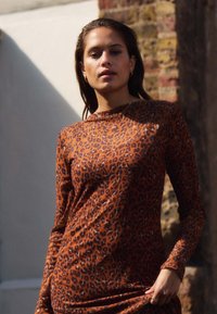 Šaty s dlouhým rukávem v leopardím vzoru v hnědé a černé barvě, přiléhavý střih, hladká textura, kulatý výstřih, s řasením v oblasti pasu.