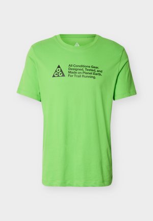 Φωτεινό πράσινο κοντομάνικο T-shirt με στρογγυλή λαιμόκοψη, με μαύρο κείμενο "All Conditions Gear" και λογότυπο ACG σε σχήμα τρίγωνου στο κέντρο του στήθους.