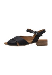 Sandalia de cuero negro con diseño de tiras cruzadas, punta abierta y correa ajustable en el tobillo. Cuenta con un tacón de bloque bajo y suela marrón.