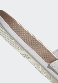 Sandal bianca con un accento in oro rosa testurizzato sulla cinghia e una suola in gomma con un motivo a diamante per una maggiore aderenza.
