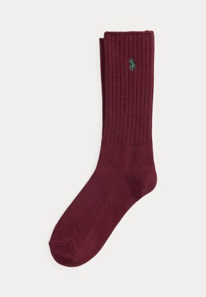 Chaussette bordeaux côtelée simple avec un logo vert brodé près du haut du bord sur fond blanc.