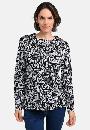 Long-sleeve top in black and white floral pattern, made of soft fabric. Features a round neckline and relaxed fit.
