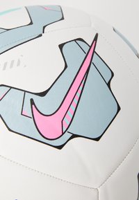 Fotbal Nike s bílým povrchem a složitými šedými a růžovými geometrickými vzory, hladkou texturou a kontrastním prošíváním.