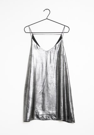 Silver metallic slip dress with thin straps hanging on black wire hanger against white background.