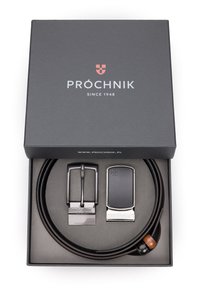 Brązowy skórzany pasek z dwiema metalowymi klamrami, jedną srebrną i jedną czarną. Zapakowany w czarne pudełko z białym brandingiem i czerwonym logo.