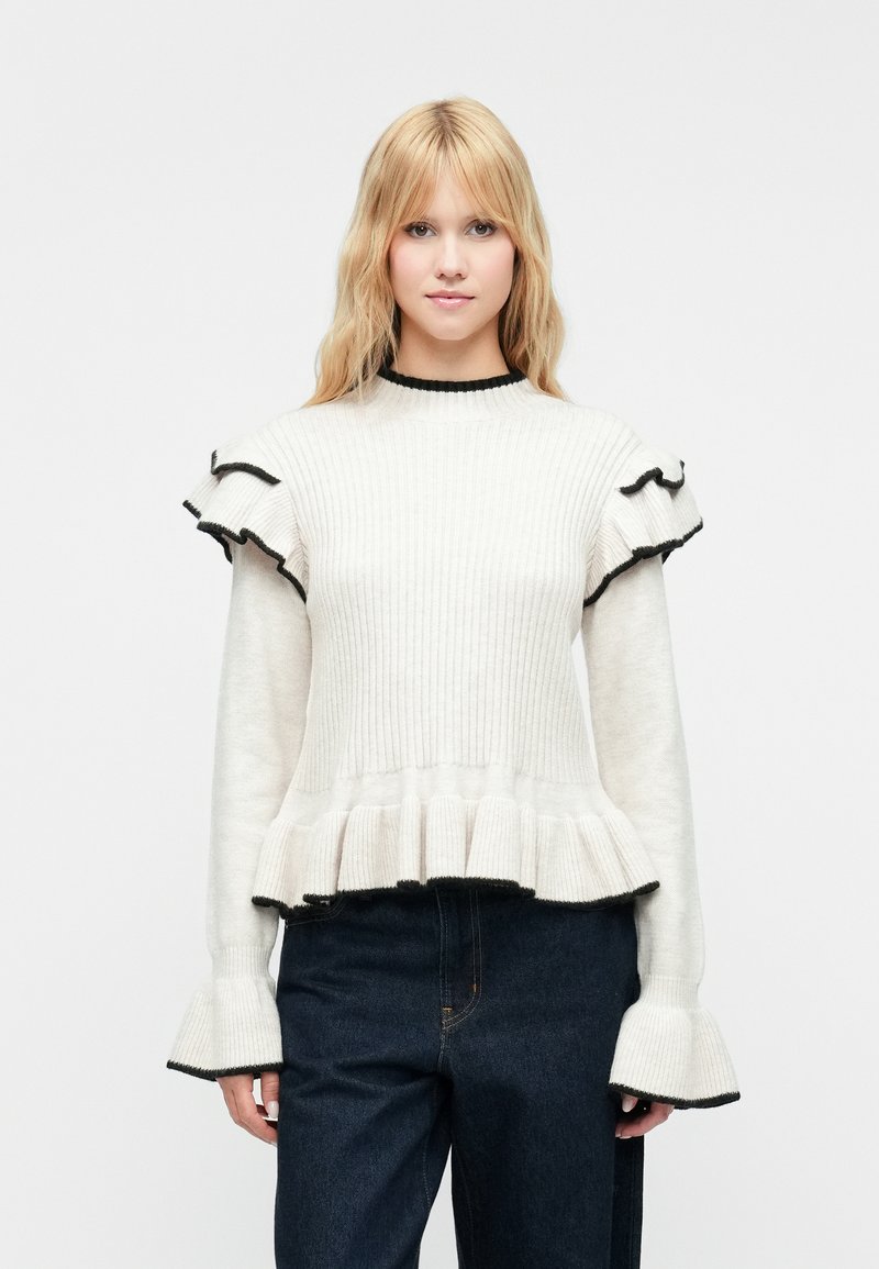 Bela rebrasta majica z črnimi obrobami, z nabrano zaveso in razširjenim spodnjim robom. Mehka tekstura in prilegajoč dizajn.