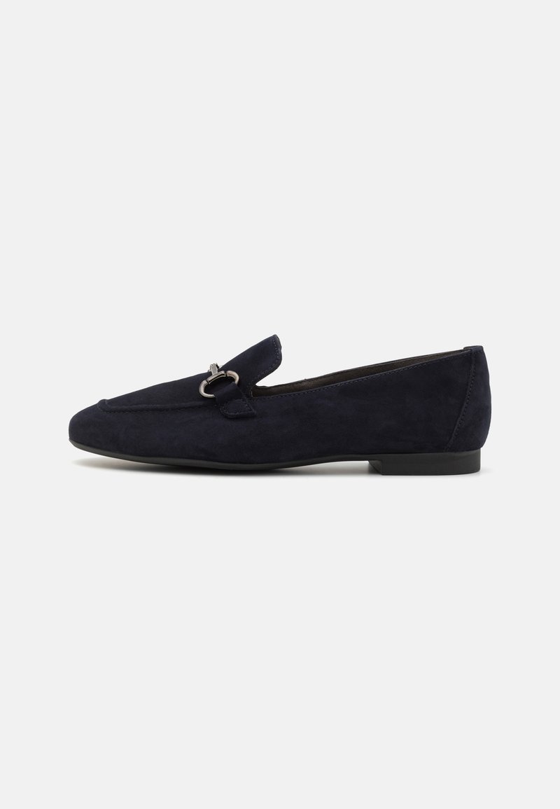 Mocassin plat en daim bleu marine avec détail boucle argentée et petit talon sur fond blanc.