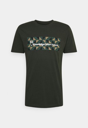 Dunkelgrünes T-Shirt mit einem geometrischen Muster in Grün und Braun hinter weißem Text "Knowledge Cotton Apparel" und einem Eulen-Logo auf der Brust.