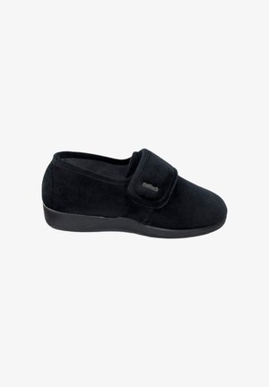 Zapatilla de velour negra con cinta de velcro, punta redondeada y superficie texturizada. Cuenta con una suela de goma plana para mayor comodidad.
