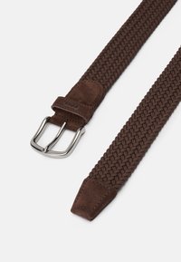 Cinto trançado castanho feito de material elástico com uma ponta em camurça e uma fivela de metal prateada. O design apresenta uma textura trançada.