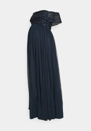 Schulterfreies Umstandsabendkleid mit paillettenbesetztem Oberteil und fließendem schwarzem Tüllrock.