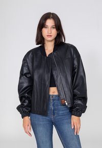 Schwarze Leder-Bomberjacke mit Reißverschluss, geripptem Kragen und elastischen Bündchen. Verfügt über eine glatte Textur und ein minimalistisches Design.