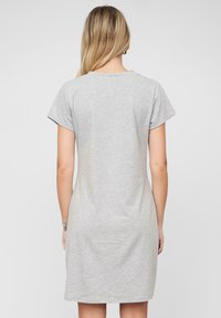 Harmaa puuvillapaita, lyhyet hihat, pyöreä pääntie, rento malli, sileä pinta, ulottuu juuri polven ylle, minimalistinen muotoilu.