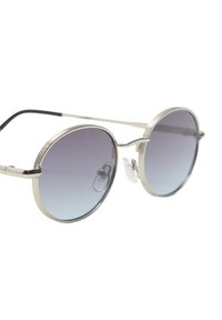 Okrągłe okulary przeciwsłoneczne z metalową srebrną oprawką. Gradientowe soczewki od ciemnego do jasnego, z delikatnymi paskami na oprawie i przezroczystymi noskami.