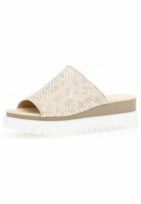 Beige schuif sandaal met een gestructureerde bovenkant en open teen. Beschikt over een dikke, witte zool met groeven en een tan middenzool voor ondersteuning.