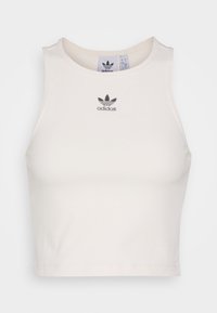 Vit ärmlös kort Adidas linne med svart trefoil-logotyp centrerad under kragen.