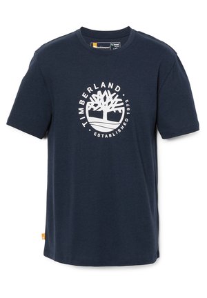 T-shirt in cotone blu navy a maniche corte con un logo circolare bianco contenente un grafico di un albero e il testo "TIMBERLAND ESTABLISHED 1973".