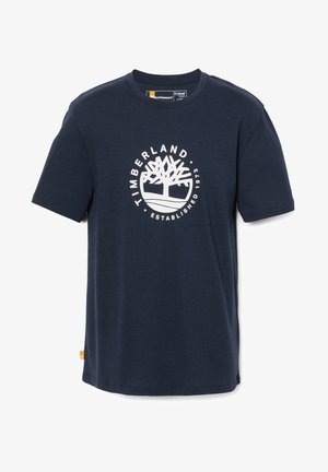 Marineblauwe katoenen t-shirt met korte mouwen, voorzien van een wit cirkelvormig logo met een boomafbeelding en de tekst "TIMBERLAND ESTABLISHED 1973".