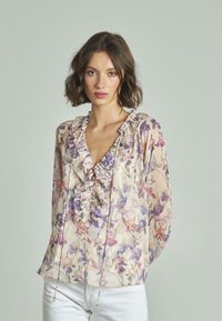 Blumenbluse aus leichtem Stoff mit rüschigem Ausschnitt, Pastellfarben mit lila und pfirsichfarbenen Blumen, lockerer Passform und Bindebändern.