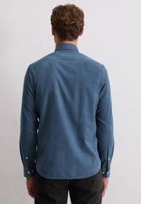 Blaues Baumwollhemd mit Rückenteil, langen Ärmeln und geknöpften Manschetten. Verfügt über einen klassischen Kragen und einen abgerundeten Saum. Glatte Textur.