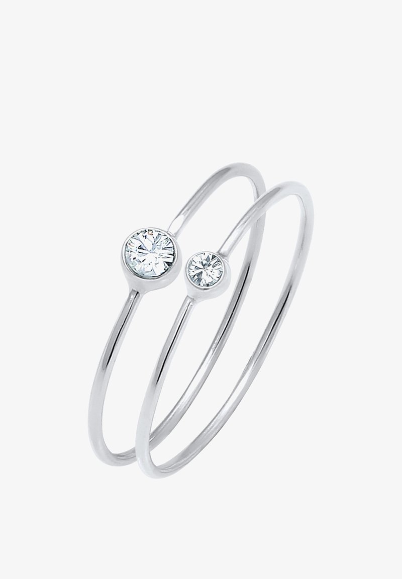 Bague double en argent avec des bandes fines, chacune comportant une pierre précieuse ronde claire, sertie en chaton, de tailles différentes.