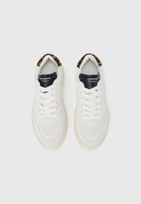 Hvite sneakers med perforert design, svart lærtunge og leopardmønstrede detaljer på kragen. Flate lisser og gummisåle.