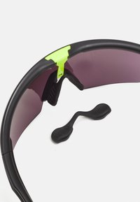 Sportsonnenbrille mit schwarzem Rahmen und lila Gläsern. Verfügt über einen neongrünen Akzent und ein geschwungenes Design mit Gummi-Nasenpads.