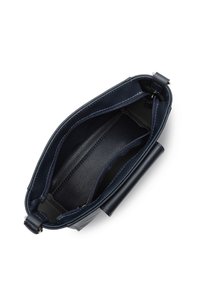 Sac à main en cuir bleu marine avec une texture lisse, fermeture à glissière et plusieurs compartiments intérieurs. Présente une couleur unie et des accents de quincaillerie minimaux.