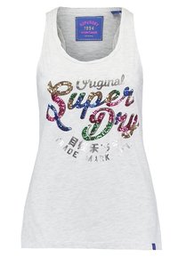 Camiseta sin mangas blanca con gráfico de "Super Dry" en lentejuelas multicolores, texto plateado y detalle de logo en el escote, hecha de tela suave.