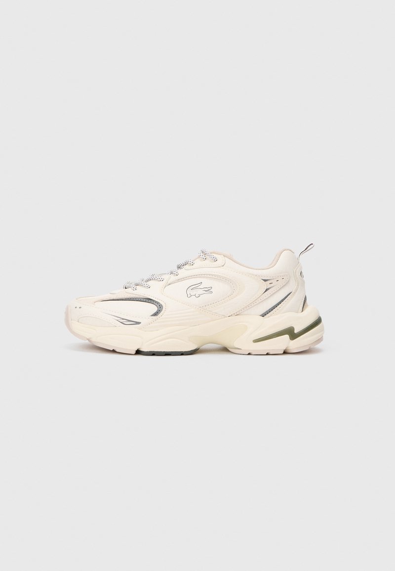 Krém színű, vastag talpú sneaker hullámos mintázatú talppal, fűzős hálós felsőrész, húzófül a sarkon és krokodil logó az oldalsó panelen.