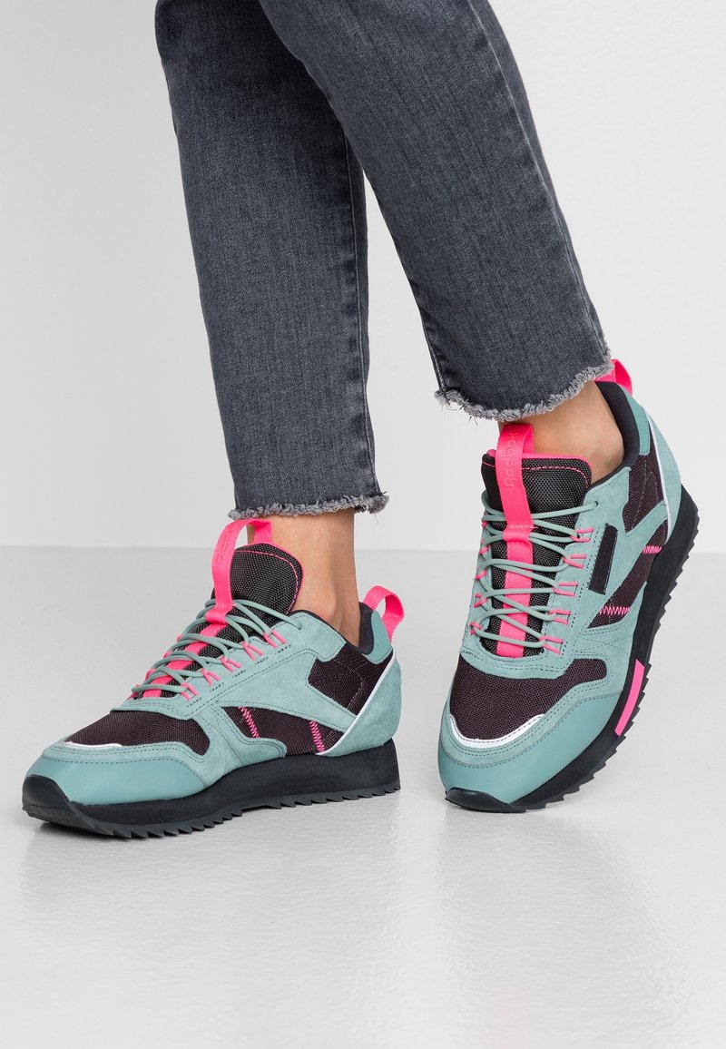 Světlé tyrkysové a černé sportovní boty s růžovými akcenty. Z semišového a síťovaného materiálu, s texturovanou podrážkou a robustním designem.
