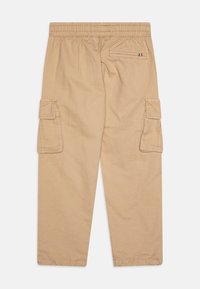 Pantalons cargos beiges avec une taille élastique, des poches cargo latérales et une seule poche arrière avec un petit détail du drapeau italien.
