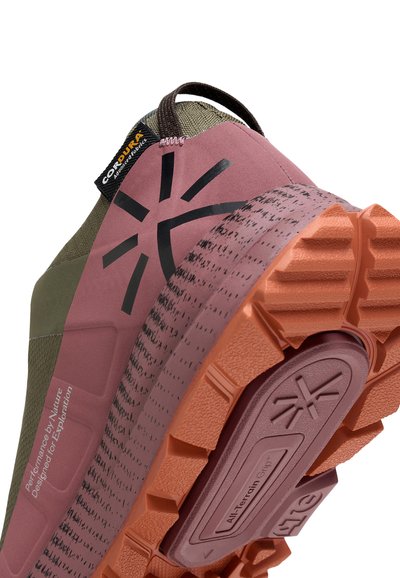 Semelle de chaussure d'extérieur avec des crampons orange profond et mauve, tige mauve avec logo noir, tissu vert olive et étiquette de marque Cordura.