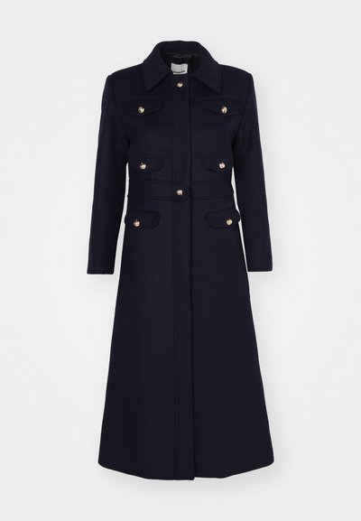 Manteau long en mélange de laine bleu marine avec un col, fermetures à boutons dorés, quatre poches avant et une silhouette ajustée.