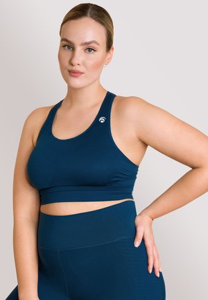 Reggiseno sportivo blu navy dal design elegante, con scollatura rotonda e logo in evidenza. Realizzato in tessuto elastico e morbido.