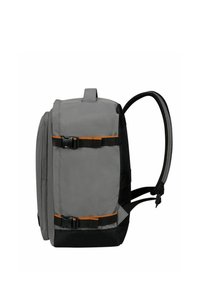 Grijze stoffen rugzak met zwarte basis, oranje accenten, verstelbare schouderbanden, een voorbuckle en een gestroomlijnde rechthoekige vorm.