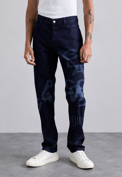 Jeans in denim blu scuro con vestibilità ampia, caratterizzati da un motivo astratto testurizzato in tonalità di blu più chiare e un classico stile a cinque tasche.