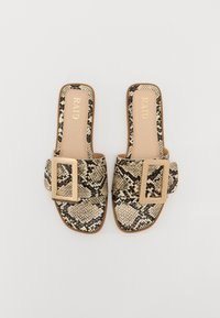 Mules met een slangenprint in beige en zwart. Een brede band met een grote gouden gesp. Gladde binnenvoering en platte zool.