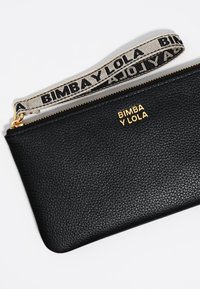 Clutch in pelle nera con finitura testurizzata, chiusura zip dorata e tracolla staccabile con un logo a motivo beige e nero.