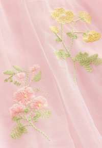 Rosa Tüllstoff mit detailreicher gelb- und pinkfarbener Blumenstickerei. Das Design umfasst grüne Blätter und filigrane Nähte.