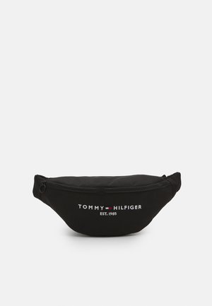 Sac banane noir avec fermeture éclair à l'avant et logo "Tommy Hilfiger EST. 1985" brodé en blanc et rouge au centre avant.