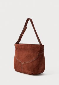 Borsa a spalla in suede marrone con un design curvo, cuciture decorative bianche e una tracolla coordinata per il trasporto.