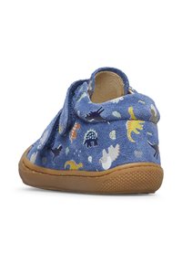 Scarpe per bambini in camoscio blu con motivo di dinosauri, collo morbido e suola in gomma color beige con grip texturizzato. Include chiusura regolabile.