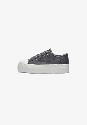 Gray denim sneakers with a white rubber sole, featuring frayed edges, gray laces, and a rounded toe design. Classic low-top style.
