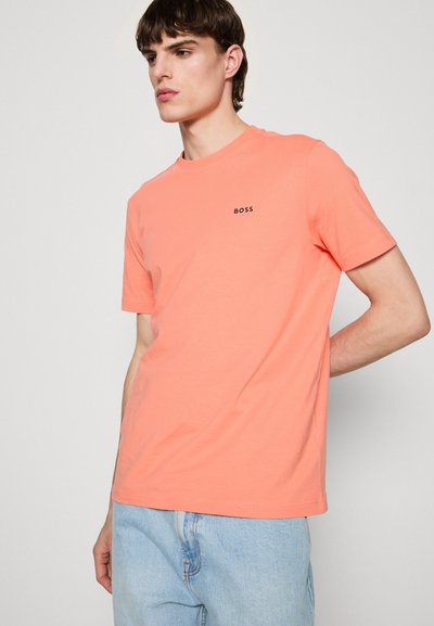 T-shirt à manches courtes de couleur corail clair avec un design ajusté et un petit logo "BOSS" noir sur la poitrine. Tissu en coton doux.