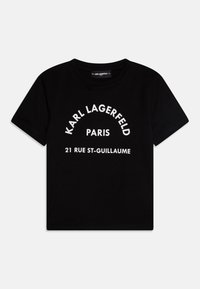 Juoda medvilninė marškinėlių palaidinė, su balta užrašu "KARL LAGERFELD PARIS 21 RUE ST-GUILLAUME" išlenkta forma. Trumpomis rankovėmis, apvaliu kaklu.
